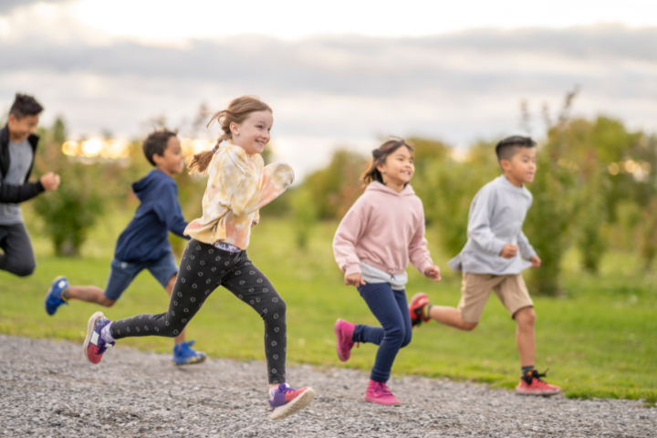 Children running and playing outdoors, supporting winter wellbeing for children through movement and active play.
